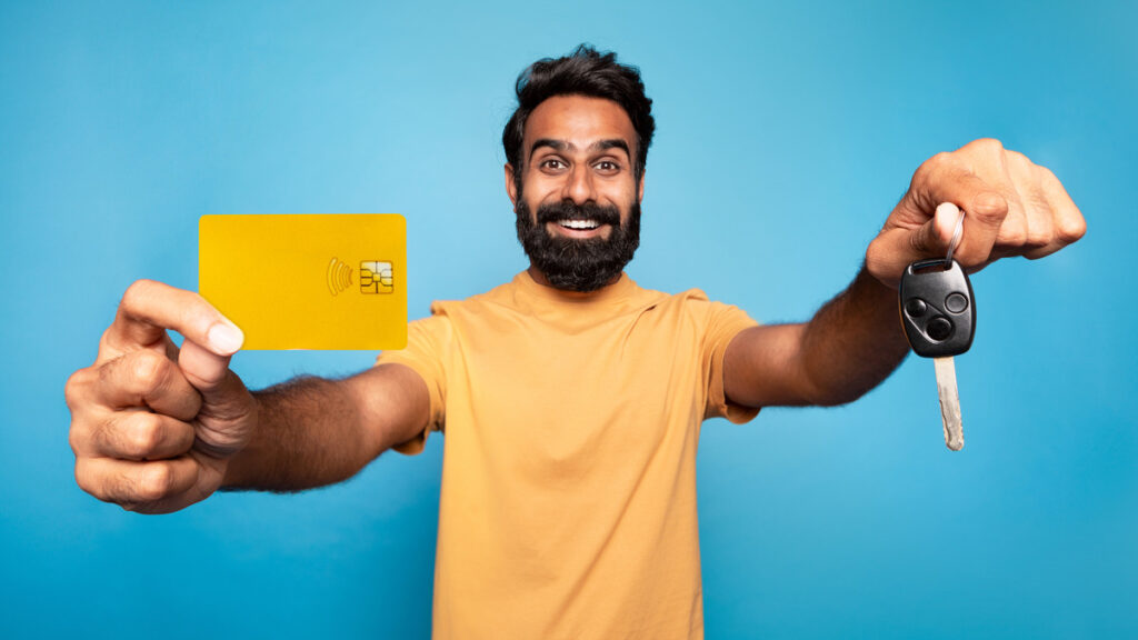 Guy holding credit card and car keys.